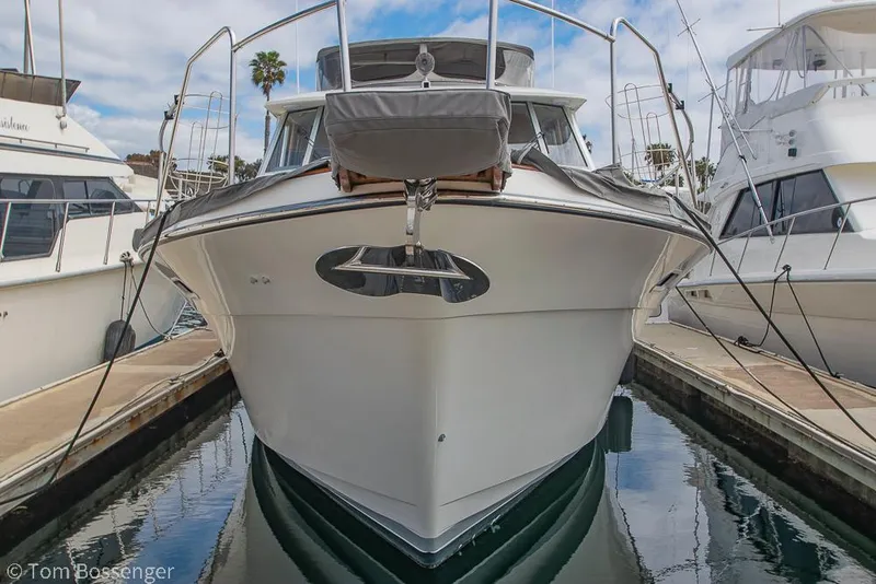 Slide: The Image of 1986 Bayliner 4588 Pilothouse yacht docked at marina, front view. - 4