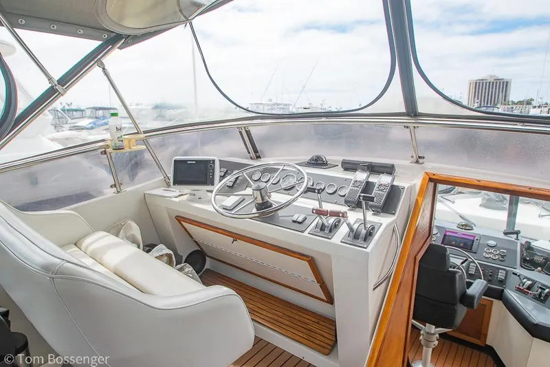 Slide: The Image of 1986 Bayliner 4588 Pilothouse interior with steering wheel, navigation equipment, and comfortable seating. - 43