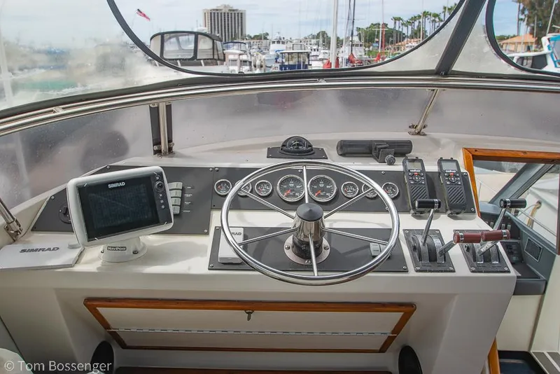 Slide: The Image of 1986 Bayliner 4588 Pilothouse helm with steering wheel, gauges, and navigation equipment. - 44