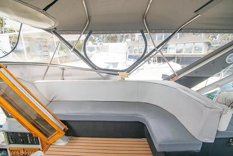 Slide: The Image of 1986 Bayliner 4588 Pilothouse interior with cushioned seating and wooden flooring. - 48