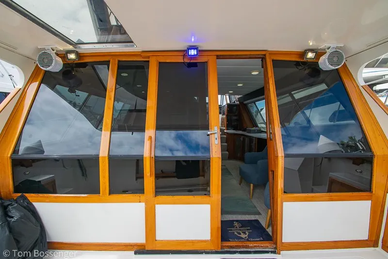 Slide: The Image of 1986 Bayliner 4588 Pilothouse yacht with wooden-framed glass doors and interior view. - 8