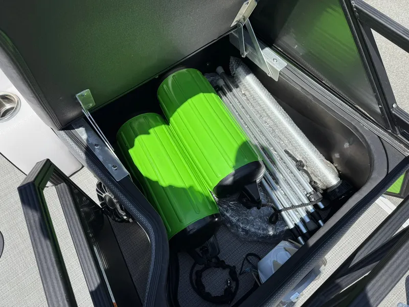 Slide: The Image of Storage compartment in 2017 Crest Caliber 230 SLR2 boat with green accessories and metal poles. - 22