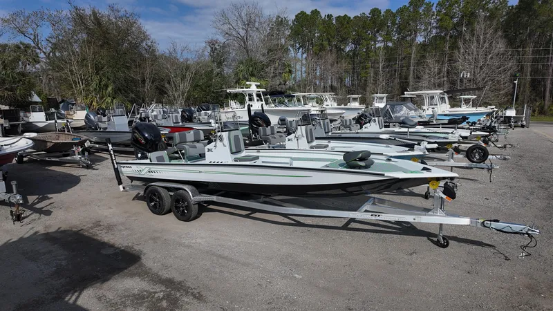 Slide: The Image of 2025 Xpress H24B boat on trailer in outdoor lot with other boats. - 10
