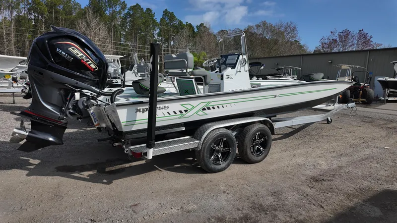 Slide: The Image of 2025 Xpress H24B boat on trailer with powerful outboard motor, parked outdoors. - 15