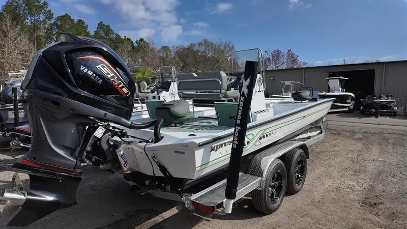 Slide: The Image of 2025 Xpress H24B boat with Yamaha engine, parked outdoors on a trailer. - 17
