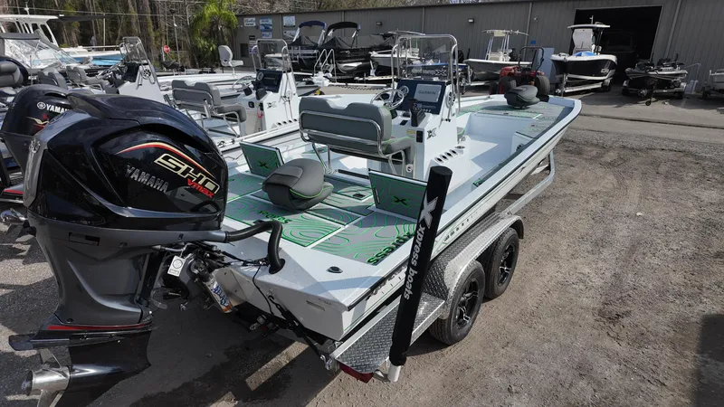 Slide: The Image of 2025 Xpress H24B boat with Yamaha engine on a trailer, parked outdoors. - 18