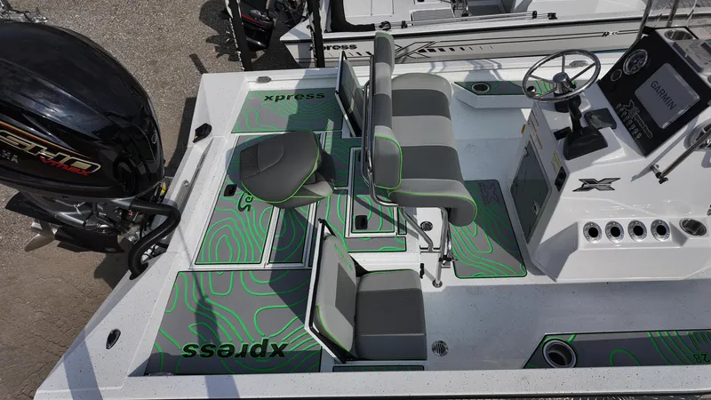 Slide: The Image of 2025 Xpress H24B boat interior with seating, console, and motor, featuring green accents. - 20