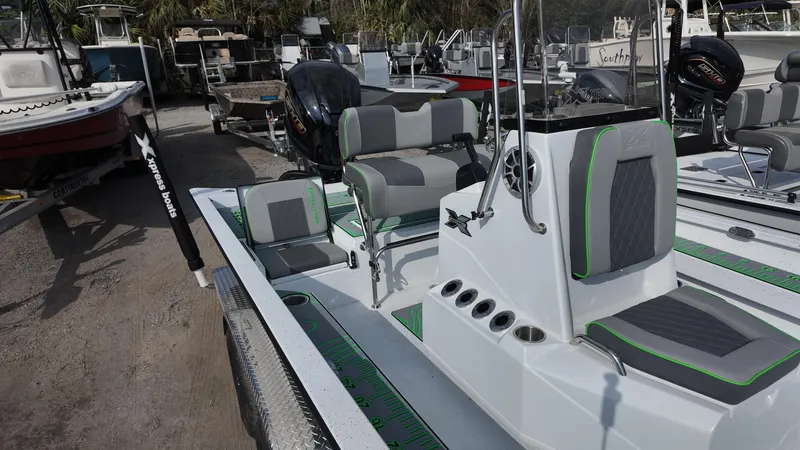 Slide: The Image of 2025 Xpress H24B boat with modern seating and sleek design in a marina setting. - 24