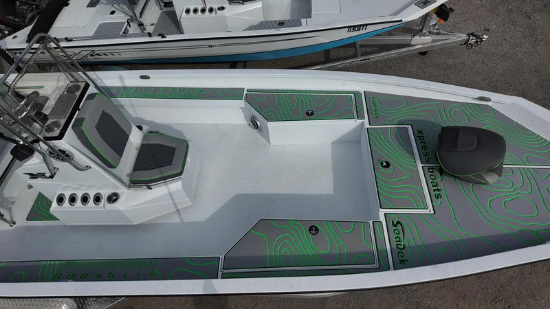 Slide: The Image of 2025 Xpress H24B boat with green patterned deck, featuring a center console and seating. - 25