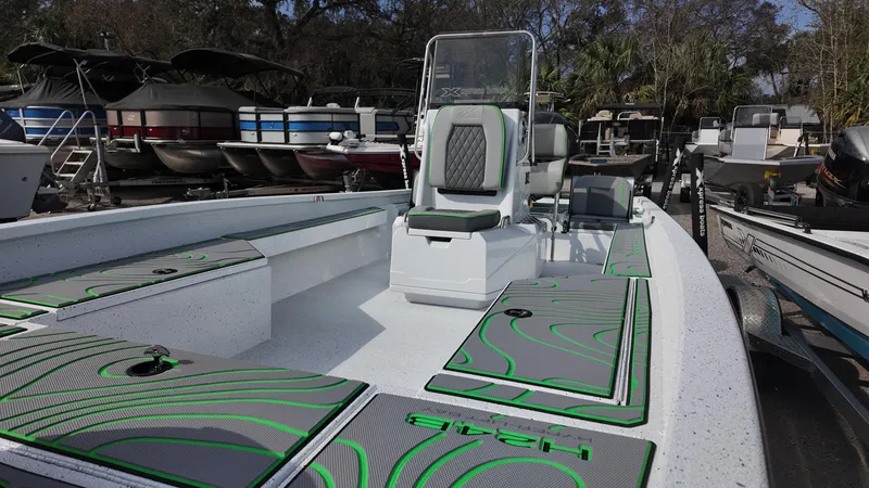Slide: The Image of 2025 Xpress H24B boat with modern seating and storage, docked among other vessels. - 28
