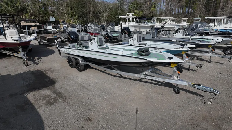 Slide: The Image of 2025 Xpress H24B boat on trailer in a marina with multiple boats. - 7