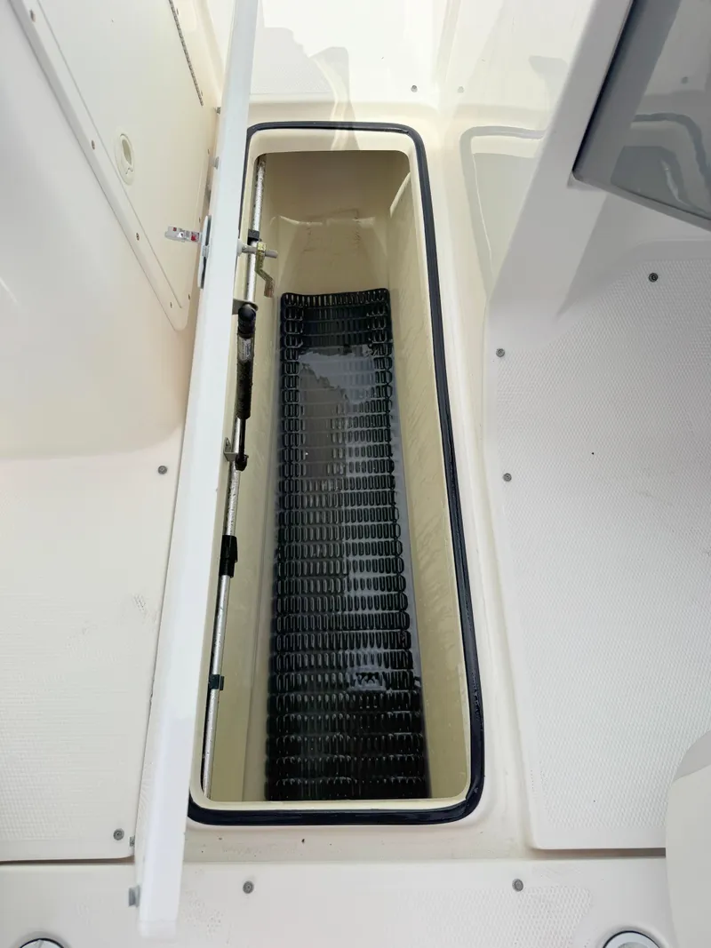 Slide: The Image of 2015 Yamaha Boats SX190 storage compartment with open lid, showcasing interior space. - 21
