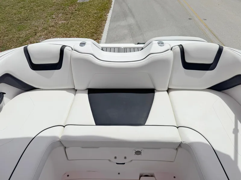 Slide: The Image of 2015 Yamaha Boats SX190 interior seating, white and black upholstery, on a road. - 24