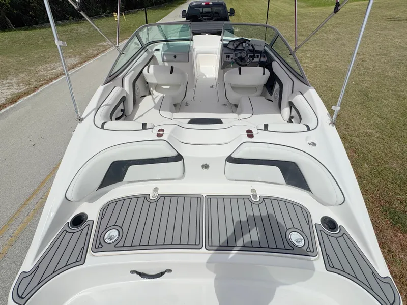 Slide: The Image of 2015 Yamaha Boats SX190 interior with seating and steering wheel, parked on a road. - 28