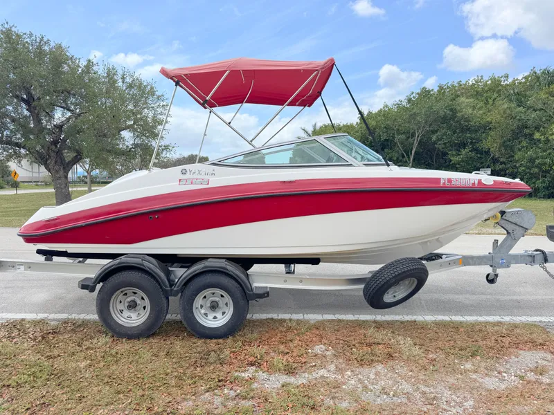 Slide: The Image of 2015 Yamaha SX190 boat with red canopy on trailer, parked outdoors. - 6