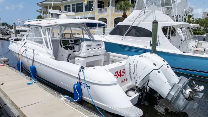 Slide: The Image of 2022 Intrepid 345 Valor boat docked at marina, featuring sleek design and powerful engines. - 11