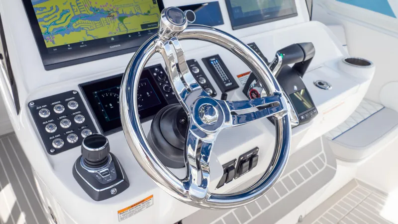 Slide: The Image of 2022 Intrepid 345 Valor boat helm with advanced navigation controls and sleek steering wheel. - 13