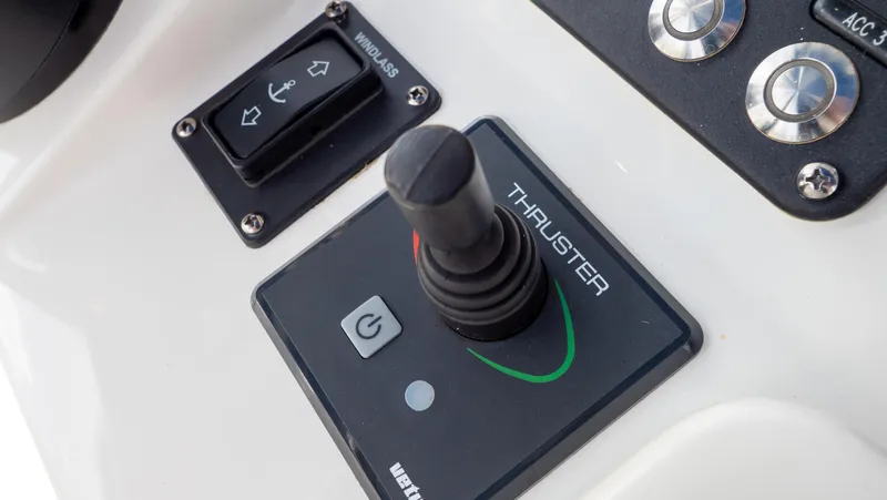 Slide: The Image of Control panel of 2022 Intrepid 345 Valor boat featuring thruster joystick and buttons. - 18