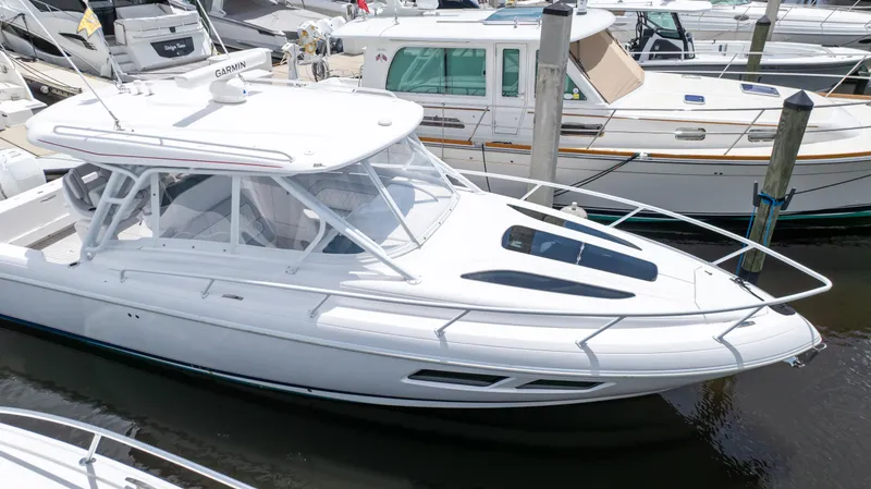 Slide: The Image of 2022 Intrepid 345 Valor boat docked in marina, sleek white design, modern features. - 28