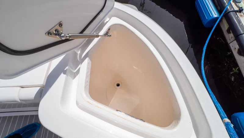 Slide: The Image of Open storage compartment on 2022 Intrepid 345 Valor boat, featuring a triangular design. - 48