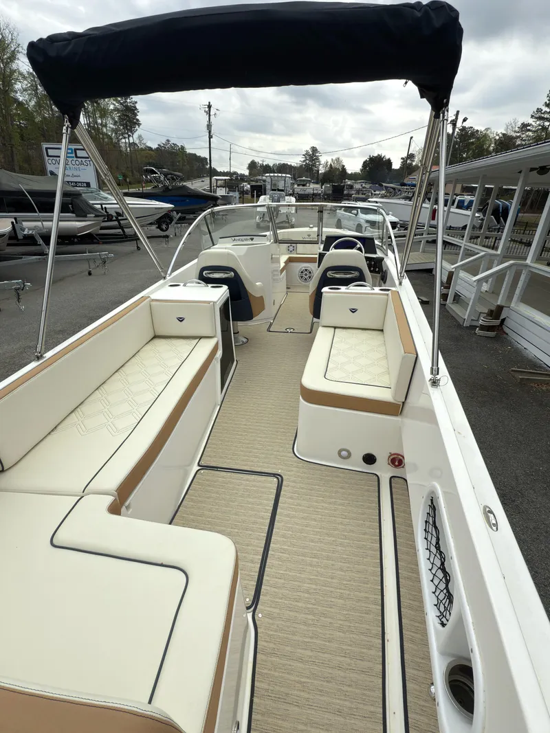 Slide: The Image of 2016 Vanquish 26 DC boat with spacious seating and canopy, docked outdoors. - 11