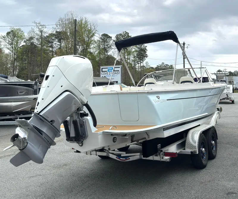 Slide: The Image of 2016 Vanquish 26 DC boat on trailer with outboard motor, parked outdoors. - 21