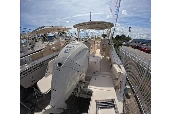 Slide: The Image of 2024 Grady-White Freedom 235 boat with powerful outboard motor, docked under clear skies. - 11