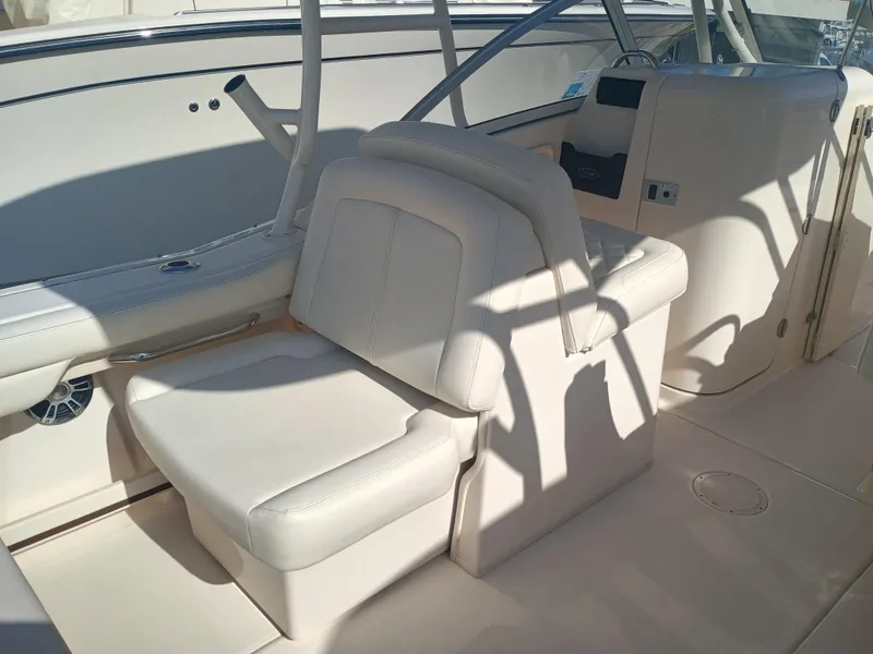 Slide: The Image of 2024 Grady-White Freedom 235 boat interior with white seating and console. - 15