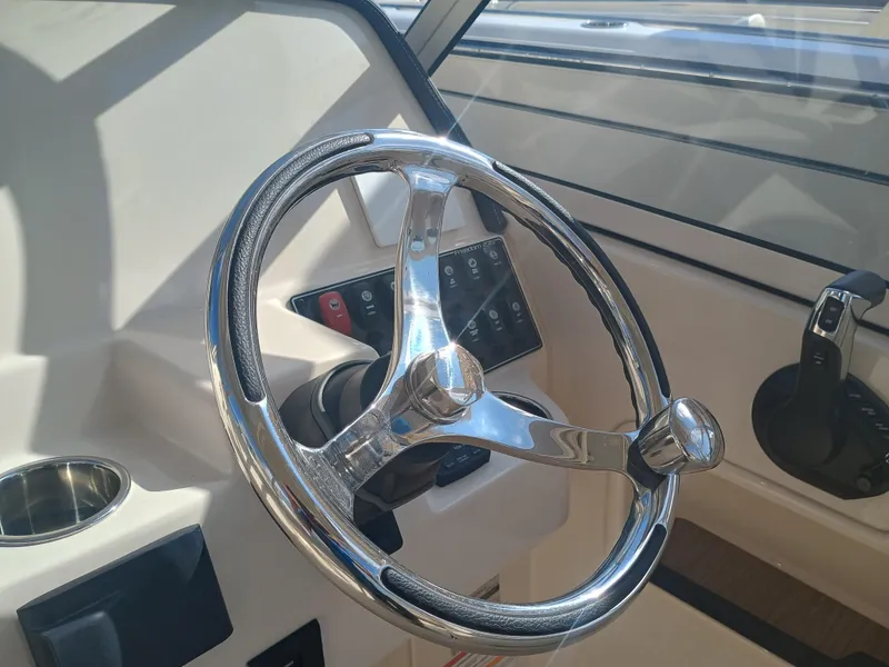 Slide: The Image of Steering wheel of 2024 Grady-White Freedom 235 boat, featuring modern controls and sleek design. - 21