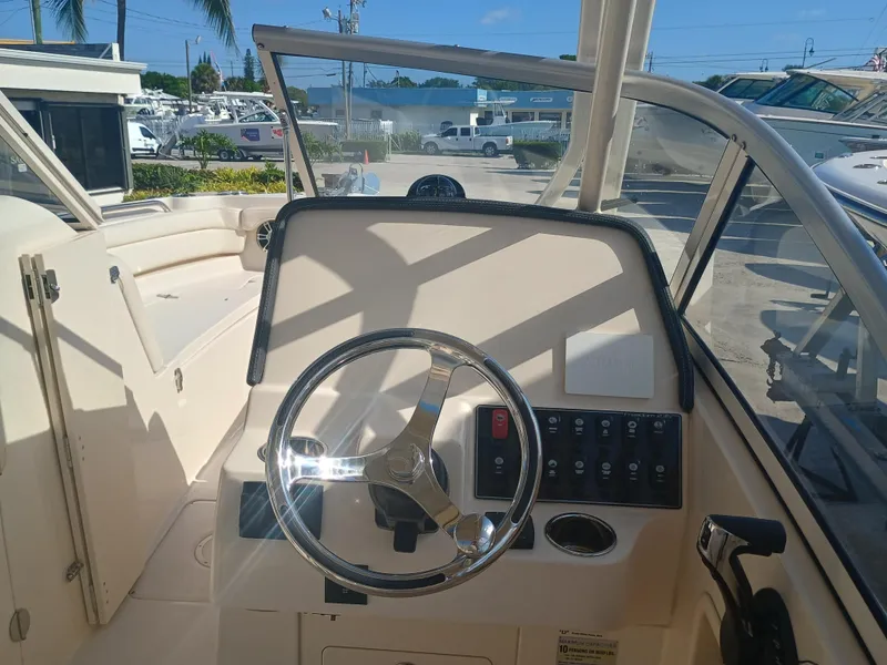 Slide: The Image of 2024 Grady-White Freedom 235 boat helm with steering wheel and control panel. - 22
