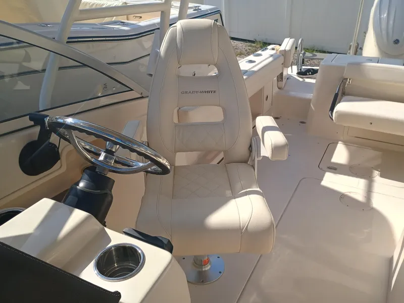 Slide: The Image of 2024 Grady-White Freedom 235 boat interior with steering wheel and captain's chair. - 23
