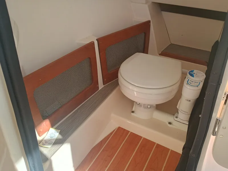 Slide: The Image of 2024 Grady-White Freedom 235 boat interior with compact marine toilet. - 26