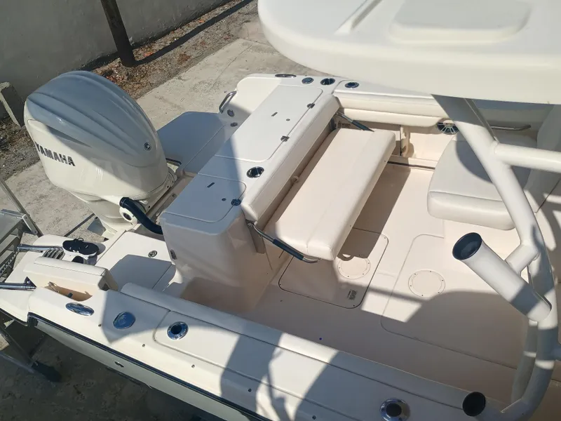 Slide: The Image of 2024 Grady-White Freedom 235 boat interior with Yamaha engine, featuring seating and storage. - 28
