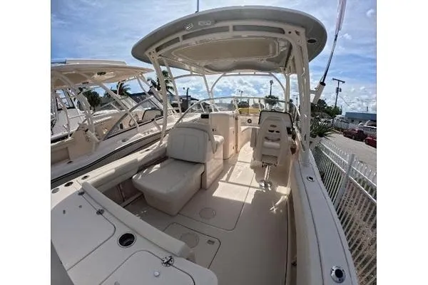 Slide: The Image of 2024 Grady-White Freedom 235 boat interior with seating and helm, under a clear sky. - 8