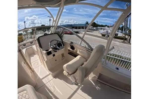 Slide: The Image of 2024 Grady-White Freedom 235 boat interior with helm, steering wheel, and seating. - 9