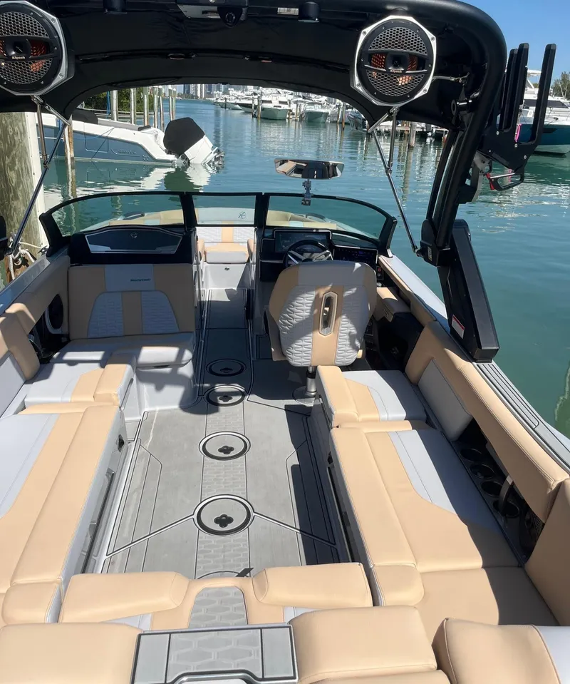 Slide: The Image of 2025 MasterCraft X24 boat interior with beige seating and advanced audio system. - 3