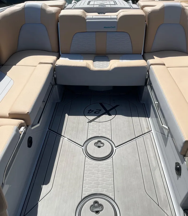 Slide: The Image of 2025 MasterCraft X24 boat interior with beige seating and sleek flooring design. - 4
