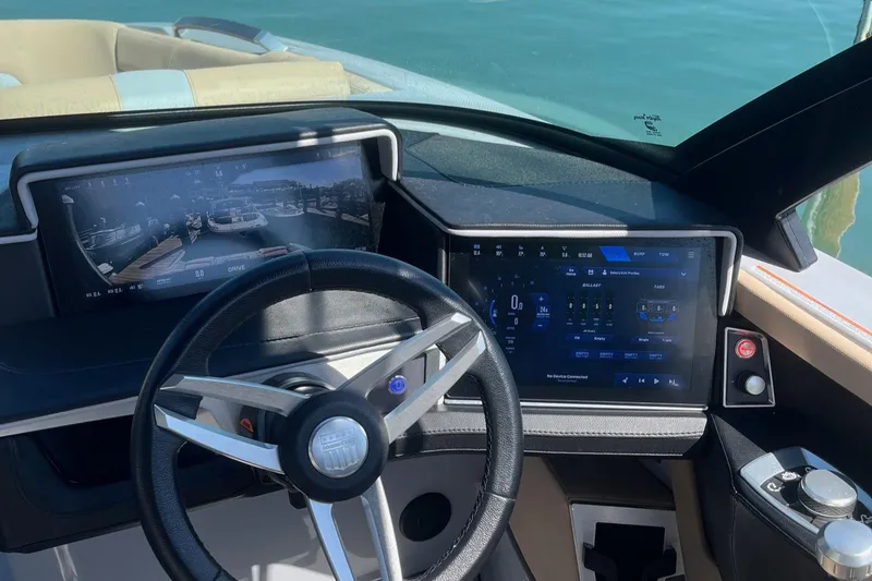 Slide: The Image of 2025 MasterCraft X24 boat dashboard with modern digital displays and steering wheel. - 5