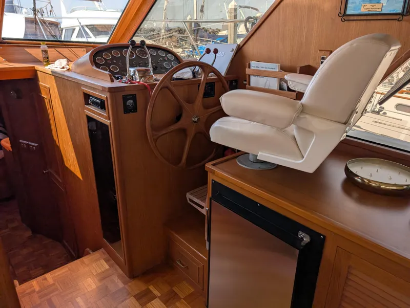 Slide: The Image of 1986 Ocean Alexander 39 Sedan helm with wooden steering wheel and captain's chair. - 19
