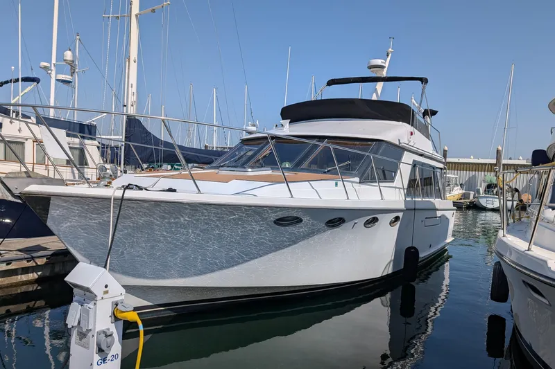 Slide: The Image of 1986 Ocean Alexander 39 Sedan yacht docked in marina, featuring sleek design and spacious deck. - 2