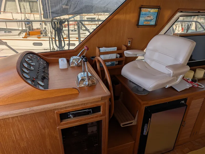 Slide: The Image of 1986 Ocean Alexander 39 Sedan helm with wooden dashboard and white captain's chair. - 23