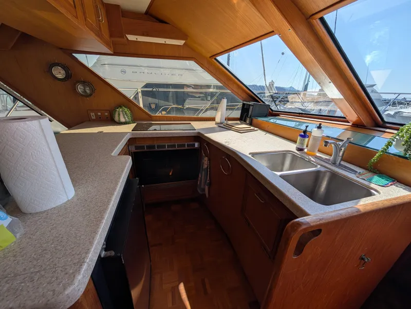 Slide: The Image of 1986 Ocean Alexander 39 Sedan yacht kitchen with dual sinks and large windows. - 25