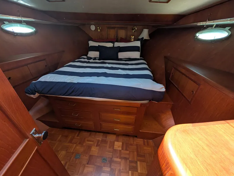 Slide: The Image of 1986 Ocean Alexander 39 Sedan cabin with striped bedding and wooden interior. - 31