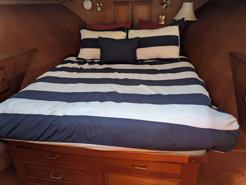 Slide: The Image of 1986 Ocean Alexander 39 Sedan cabin with striped bedding and wooden interior. - 32