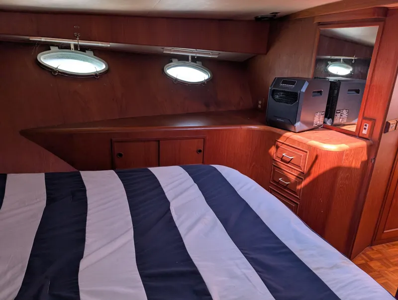 Slide: The Image of Cabin interior of 1986 Ocean Alexander 39 Sedan with striped bedding and porthole windows. - 34