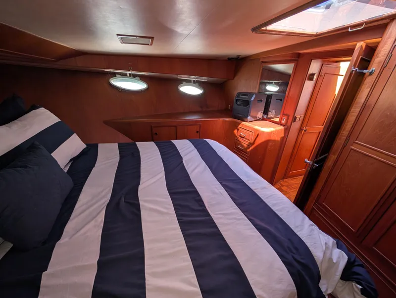 Slide: The Image of 1986 Ocean Alexander 39 Sedan cabin with striped bedding and wooden interior. - 35