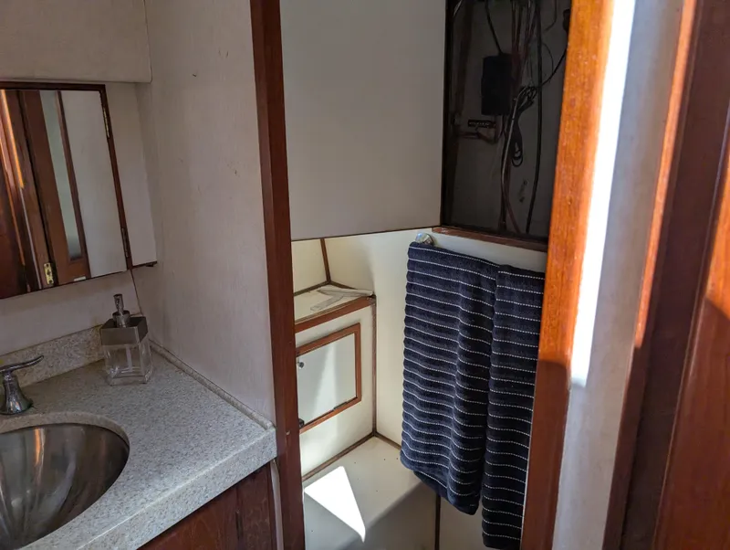 Slide: The Image of 1986 Ocean Alexander 39 Sedan bathroom with sink, mirror, and striped towel. - 39