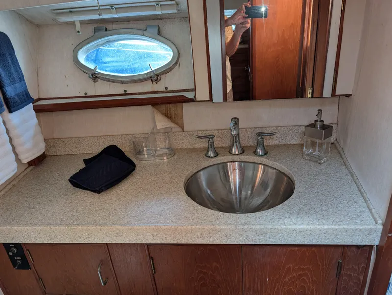 Slide: The Image of 1986 Ocean Alexander 39 Sedan bathroom with sink, mirror, and porthole window. - 41