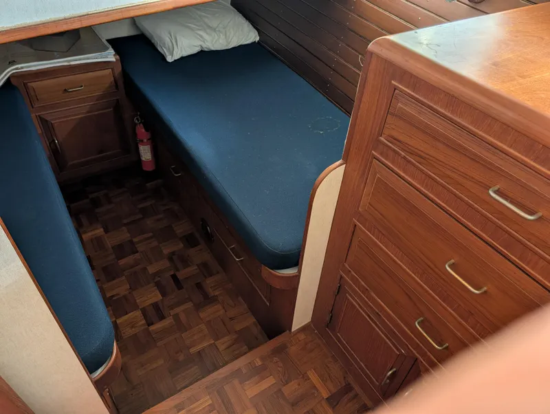 Slide: The Image of 1986 Ocean Alexander 39 Sedan cabin with wooden interior and blue bedding. - 45