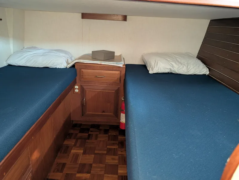 Slide: The Image of Twin cabin beds in 1986 Ocean Alexander 39 Sedan yacht, featuring wooden cabinetry and blue bedding. - 48